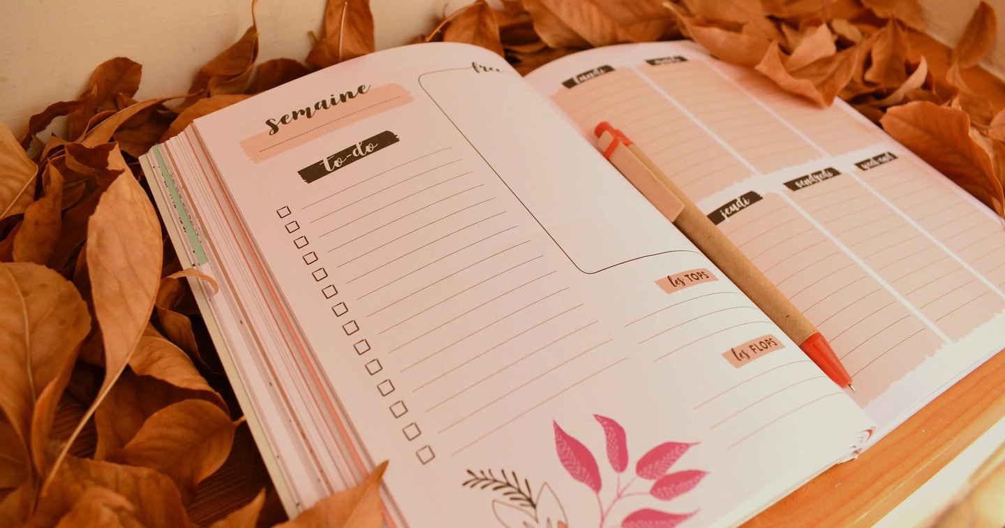 Agenda de jardinage posé parmi des feuilles, symbole d’un calendrier de culture pour balcon